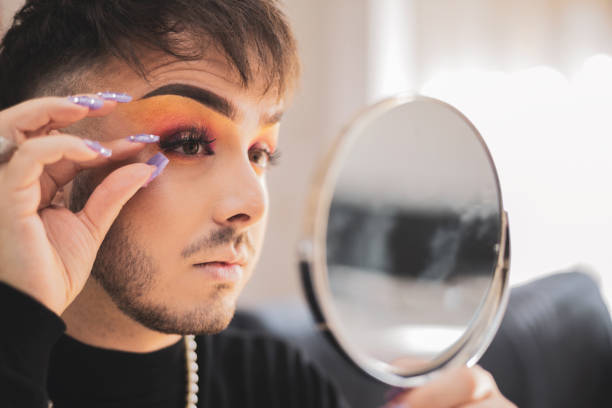 istock A young gay man putting on a false eyelash while putting on makeup before going outside. 1435383623