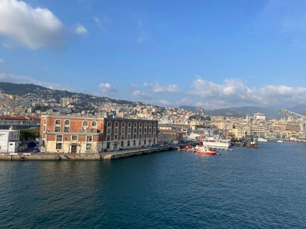 wide panoramic view of the harbor of Genoa. Blue sky blue sea white clouds and port buildings in harmony with the surrounding Mediterranean landscape wide panoramic view of the harbor of Genoa. Blue sky blue sea white clouds and port buildings in harmony with the surrounding Mediterranean landscape High quality photo merchants gate stock pictures, royalty-free photos & images