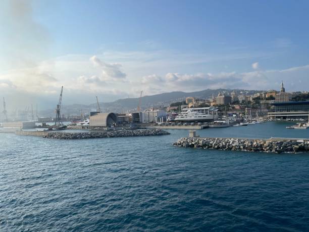 wide panoramic view of the harbor of Genoa. Blue sky blue sea white clouds and port buildings in harmony with the surrounding Mediterranean landscape wide panoramic view of the harbor of Genoa. Blue sky blue sea white clouds and port buildings in harmony with the surrounding Mediterranean landscape High quality photo merchants gate stock pictures, royalty-free photos & images