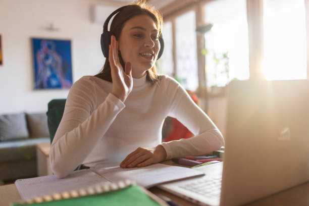 istock Young adult student watching class and learning online at home 1435385629