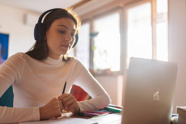 istock Young adult student watching class and learning online at home 1435385650