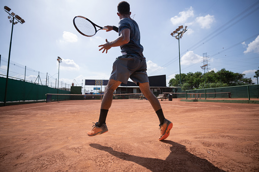 Paddle tennis player returning the ball with forehand