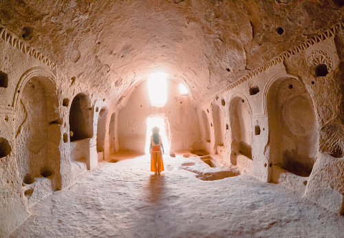 Joven viajera está caminando dentro de una iglesia cueva en la antigua ciudad de Zelve en Capadocia en Nevsehir, Turquía photo