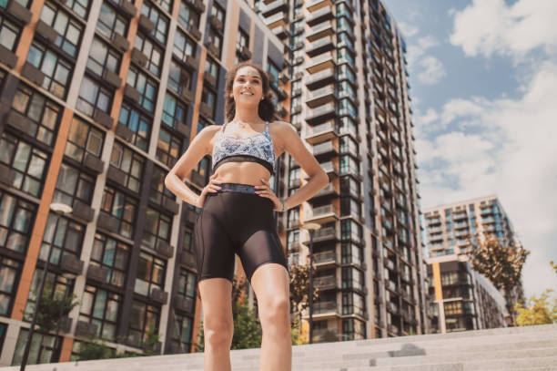 Slim girl in tight sportwear standing on the urban background Urban life. Slim girl in tight sportwear standing on the urban background cycling shorts stock pictures, royalty-free photos & images