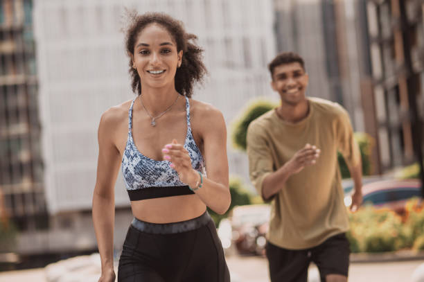 istock Two young people running and smiling 1435389996