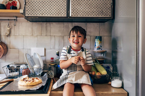 istock Boy Sitting On The Kitchen Counter 1435390502