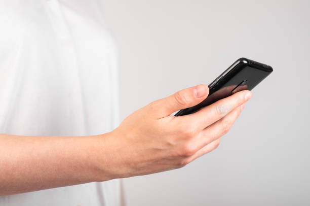Woman hand holding phone. Using device in common life. Profile view