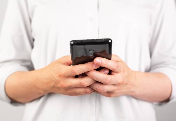 Woman hands texting message at phone. Female using Android for instant messaging, sharing photos, videos in messengers or typing SMS. Frontal view