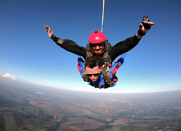 przyjaciele z tandemu sky dive o zachodzie słońca. - extreme sports parachute copy space parachuting zdjęcia i obrazy z banku zdjęć