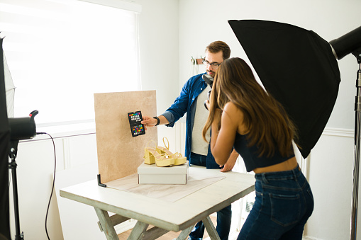 Photographers using a color card while preparing to do a fashion photo shoot with a softobox