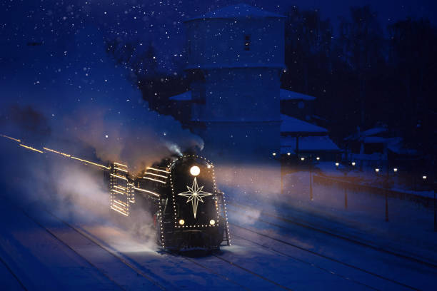 istock festively decorated with lights retro Christmas train on rails, snowy evening 1435399089