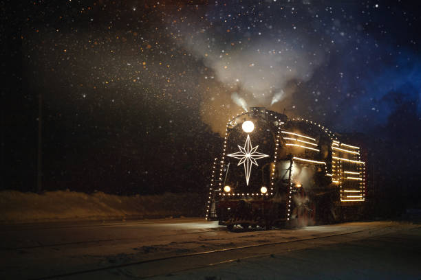 istock festively decorated with lights retro Christmas train on rails, snowy evening 1435399090