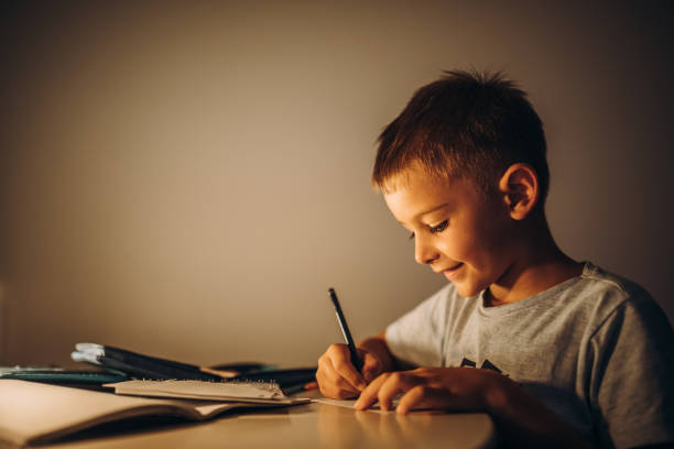 istock Child holding a pen and writing / drawing in low light 1435399228