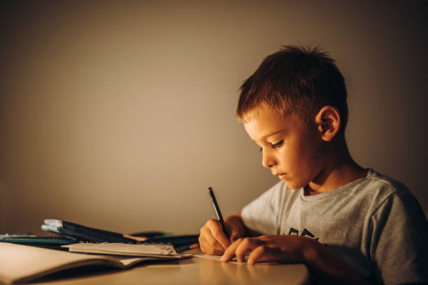 istock Child holding a pen and writing / drawing in low light 1435399240