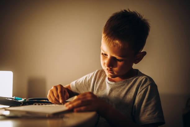 istock Child holding a pen and writing / drawing in low light 1435399246