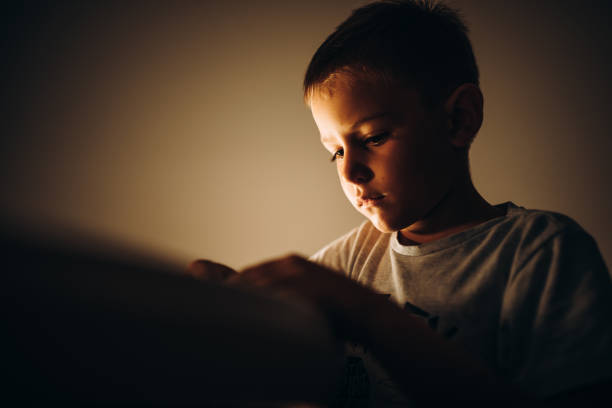 istock Child holding a pen and writing / drawing in low light 1435399660