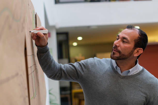 istock latin business man inside his work office giving a brief explanation to his co-workers 1435399880