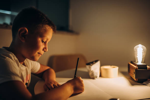 istock Child holding a pen and writing / drawing in low light 1435399951
