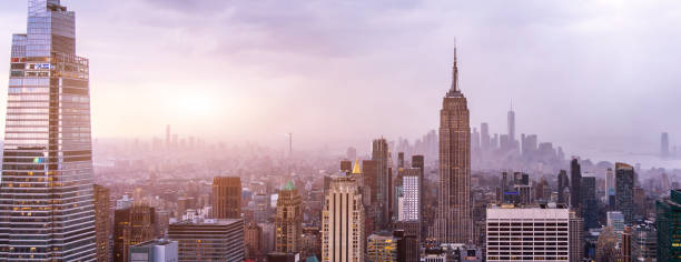 Panoramic view of fog or low cloud over skyscrapers at dusk