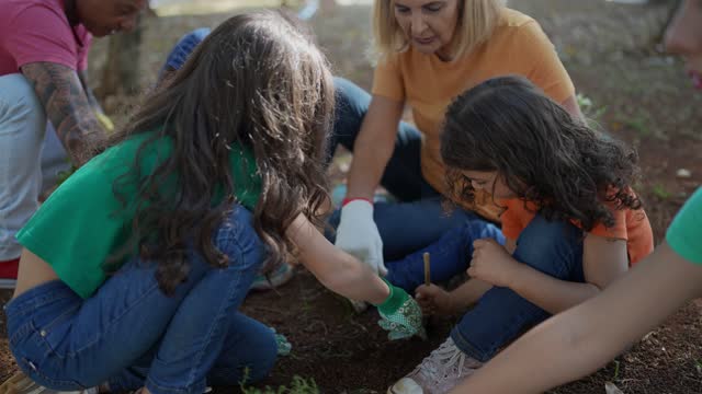 Grandmother and granddaughters planting at a publica park