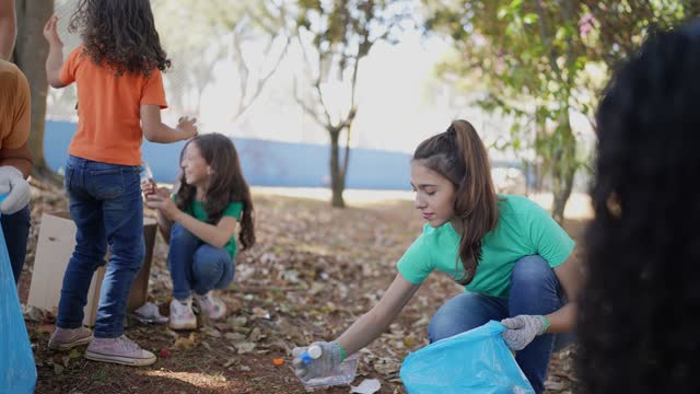 Young woman picking up garbage to clean a public park