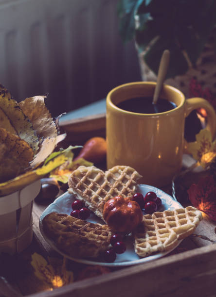 Wooden tray with breakfast and a garland on the bedside table.