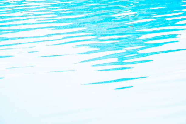 Blurred transparent blue colored clear calm water surface texture with splashes and bubbles. Trendy abstract nature background. Water waves in sunlight. water background stock photo