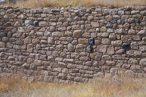 Old rough rugged stone wall or exterior structure from 1880s gold mining town in Colorado in the town of Victor in western USA of North America.