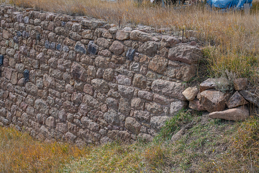 A hole in the old stone wall of the fortress. Wall masonry made of natural stone.