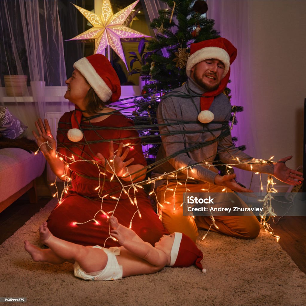 Foto de Pais Livres Com Uma Criança Pequena Na Véspera De Ano Novo Uma  Família Com Um Bebê Recémnascido Na Árvore De Natal Na Sala De Estar Da  Noite e mais fotos
