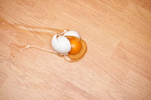 broken egg on the wooden floor at kitchen