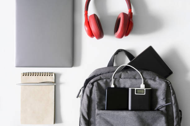 istock Small textile urban backpack on a white surface along with a laptop, an external battery - a power bank, a mobile phone, headphones, a tablet, a notepad and a fountain pen. 1435449309