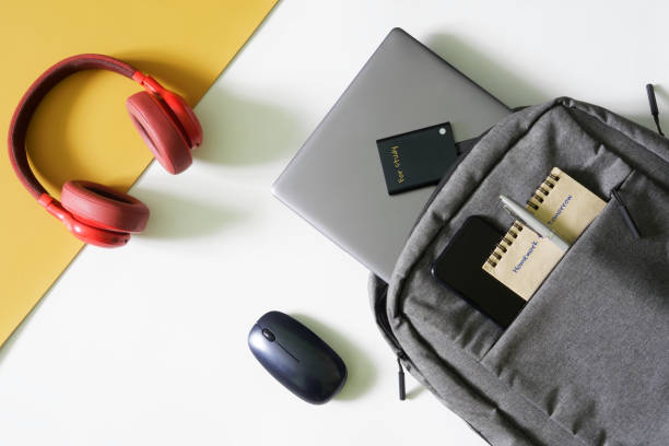 istock Gray urban backpack with a laptop, notepad, fountain pen, external ssd, mouse, headphones and smartphone. The concept of a backpack and gadgets for study. Modern student's bag. 1435449378