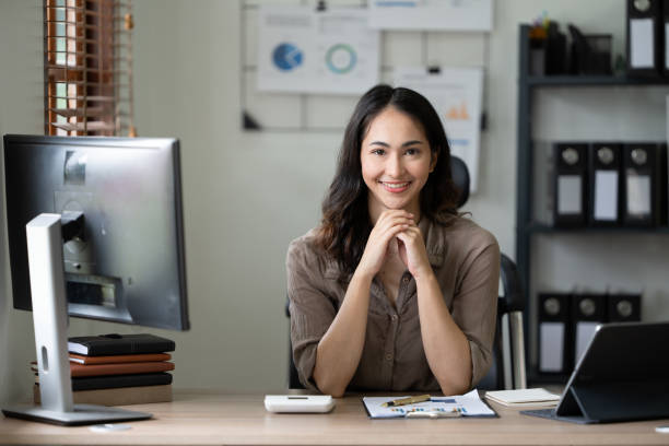 istock Beautiful smiling young woman working on computer at her workplace in office 1435453059