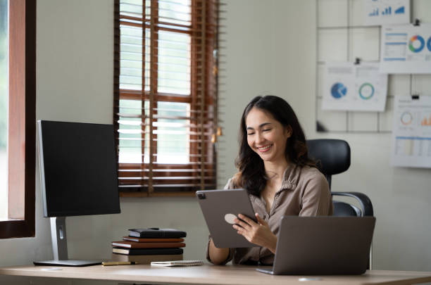 istock Beautiful smiling young woman working on computer at her workplace in office 1435457443