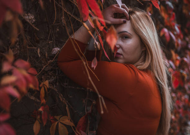 A beautiful plus size woman is enjoying an autumn day