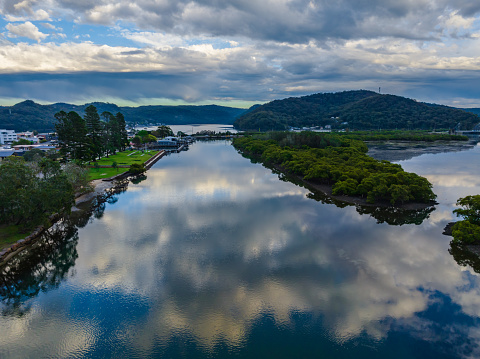 Scenic aerial views as the storm passes over the coastal waters with clouds and reflections in Woy Woy on the Central Coast, NSW, Australia.