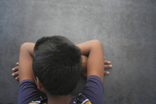 Sad young guy sitting in a dark room