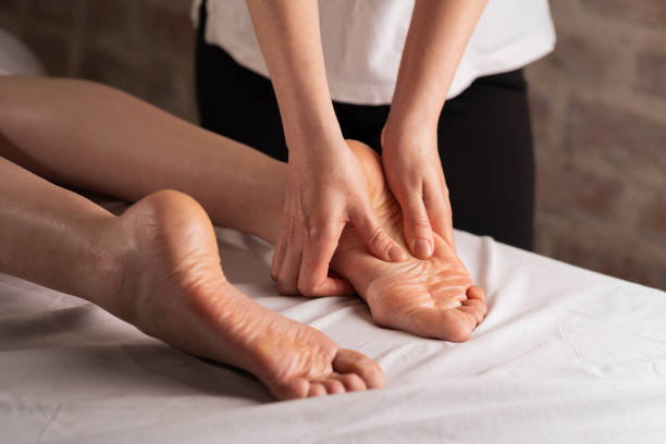 massaggio ai piedi della donna nel salone della spa, massaggiatore massaggiatore piedi massaggiante - foot massage foto e immagini stock