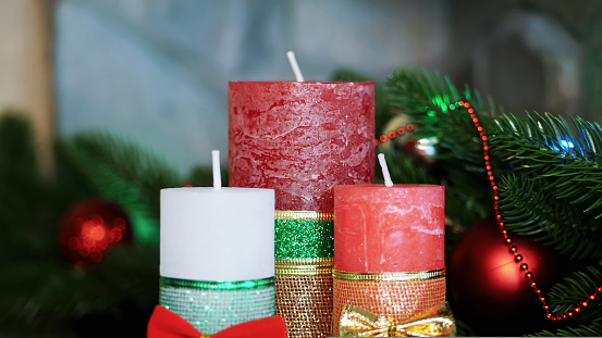 Christmas background with two white advent candles and golden decoration.