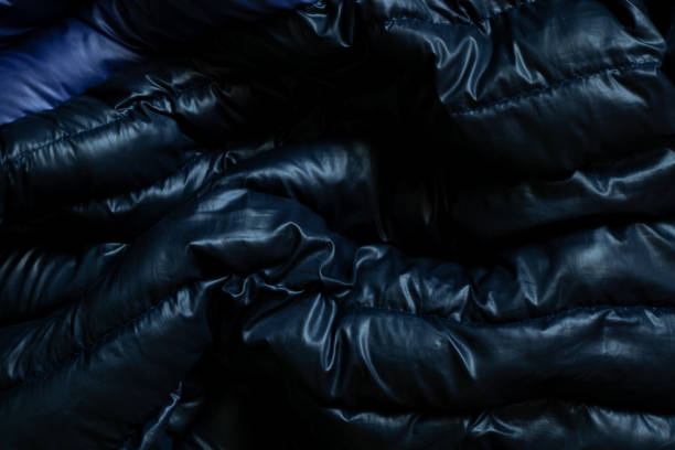 istock black puffed men's winter jacket as background, down jacket close up 1435477417