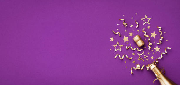 紫の背景に金色のシャンパンボトルと紙吹雪の星とパーティーの装飾。クリスマス、誕生日、または年賀状。 - invitation birthday card creativity ideas ストックフォトと画像