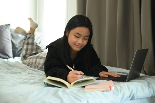 istock Happy teenage girl studying virtual course, learning distance class via laptop and making note on notebook. 1435490551