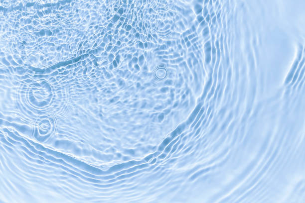 Photo of Waves on clear water surface with blue abstract background.