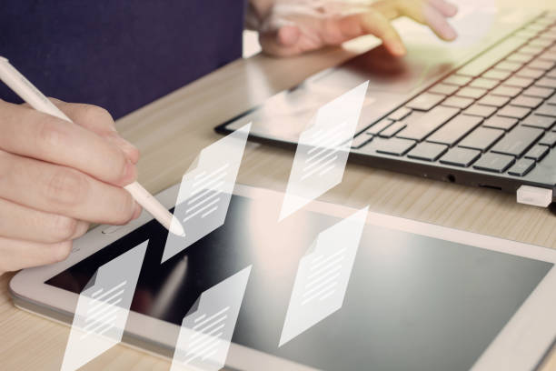 Woman holds pen and writing to send electronic document or take note and another hand using laptop. Business and Marketing strategy and concept.