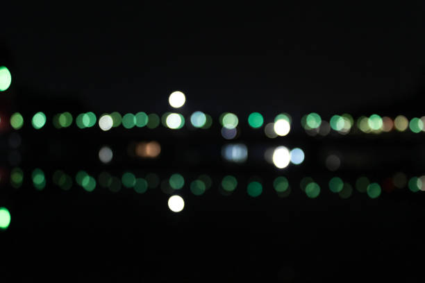 night view of a bridge showing blurred light and reflection of light on water