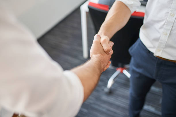 istock Two businessmen shaking hands at office 1435507445