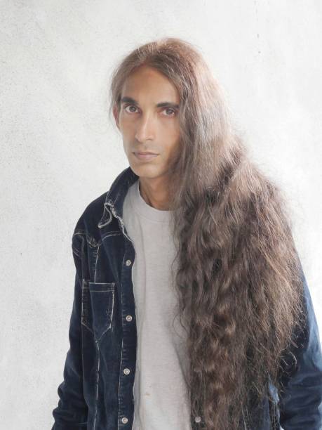 Man with long soft brown hair looking at camera