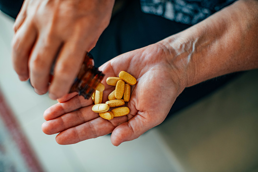 Senior Woman is Holding Vitamin C Pills in Her Palm