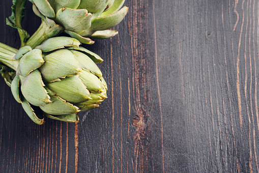 Fresh artichoke flower on wooden background